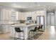Bright, modern kitchen features white cabinetry, stainless steel appliances, and a center island with barstool seating at 1423 W Wood St, Tampa, FL 33604