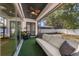 Covered outdoor patio featuring a comfortable sofa and lush green carpeting offering views of the backyard at 1423 W Wood St, Tampa, FL 33604