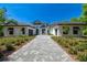 Beautiful home exterior boasts a paver driveway, manicured landscaping, and a modern design at 17720 Royal Eagle Ln, Lutz, FL 33549