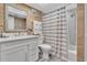 The bathroom has a shower, vanity, mirror, and beach-themed decor and is well-lit at 200 120Th W Ave # 3A, Treasure Island, FL 33706