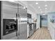 Modern kitchen with stainless steel appliances, white cabinets, and light-blue tile backsplash at 200 120Th W Ave # 3A, Treasure Island, FL 33706