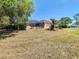 Large backyard with a screened pool and mature landscaping, providing a private and relaxing outdoor space at 2017 Godfrey Ave, Spring Hill, FL 34609