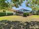Manicured backyard featuring a screened-in pool area and lush landscaping, ideal for relaxation and privacy at 2017 Godfrey Ave, Spring Hill, FL 34609