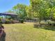 Spacious backyard with a screened-in pool area and mature trees, perfect for outdoor entertaining at 2017 Godfrey Ave, Spring Hill, FL 34609