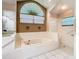 Bright bathroom with tub, large window, and shower with safety bars at 2017 Godfrey Ave, Spring Hill, FL 34609