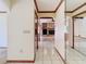 Bright hallway with tile flooring, wood trim, archways, and mirrors reflecting the open floor plan at 2017 Godfrey Ave, Spring Hill, FL 34609