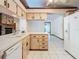Well-lit kitchen boasts ample cabinet space, white appliances, and tiled flooring at 2017 Godfrey Ave, Spring Hill, FL 34609