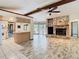 The open living room features a stone fireplace, beamed ceilings, and views of the kitchen and pool area at 2017 Godfrey Ave, Spring Hill, FL 34609