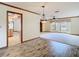 Open-concept living area featuring wood-look tile flooring, neutral walls, and abundant natural light at 2017 Godfrey Ave, Spring Hill, FL 34609
