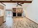 The open living room features a stone fireplace, beamed ceilings, and views of the pool area at 2017 Godfrey Ave, Spring Hill, FL 34609