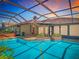 Enjoy this sparkling pool with steps and metal railing surrounded by enclosed lanai with great sunset views at 2017 Godfrey Ave, Spring Hill, FL 34609