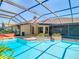 Relax by this pristine pool with surrounding brick trim and lush landscaping in an enclosed lanai at 2017 Godfrey Ave, Spring Hill, FL 34609