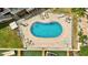 Aerial view of a private backyard pool with a brick patio, lounge chairs and waterfront views at 234 Dolphin Pt # 1, Clearwater Beach, FL 33767