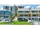 Exterior backyard view featuring white balconies, lush lawn, and waterfront scenery at 234 Dolphin Pt # 1, Clearwater Beach, FL 33767