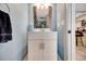 Stylish half-bathroom featuring a decorative mirror and neutral tones at 234 Dolphin Pt # 1, Clearwater Beach, FL 33767