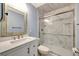 Beautifully renovated bathroom featuring marble style walk-in shower, white vanity, and custom mirror at 234 Dolphin Pt # 1, Clearwater Beach, FL 33767