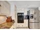 Cozy kitchen featuring stainless steel refrigerator, modern appliances, and white cabinetry at 234 Dolphin Pt # 1, Clearwater Beach, FL 33767