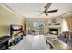 Bright living room with a modern fireplace, a ceiling fan, and a sliding glass door to the patio at 234 Dolphin Pt # 1, Clearwater Beach, FL 33767
