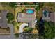 Aerial view of house featuring a screened-in pool surrounded by lush greenery and a well-manicured lawn at 2904 Pointer Pl, Seffner, FL 33584
