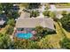 Aerial view of house featuring a screened-in pool surrounded by lush greenery and a well-manicured lawn at 2904 Pointer Pl, Seffner, FL 33584