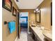 Stylish bathroom with double sinks, tile countertops, wood cabinets, and a view into the bedroom at 2904 Pointer Pl, Seffner, FL 33584