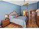 A cozy bedroom with blue walls, wood floors, ceiling fan and en-suite bathroom access at 2904 Pointer Pl, Seffner, FL 33584
