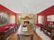 Formal dining room features long wooden table, stone fireplace, and red accent walls at 2904 Pointer Pl, Seffner, FL 33584