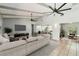 Bright living room featuring vaulted ceilings with wooden beams, two ceiling fans and neutral tones at 2904 Pointer Pl, Seffner, FL 33584