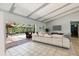 Spacious living room featuring white tile floor, high ceiling with beams, and screened outdoor patio at 2904 Pointer Pl, Seffner, FL 33584
