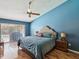Spacious primary bedroom with blue walls, wood floors, ceiling fan and view to backyard and pool at 2904 Pointer Pl, Seffner, FL 33584