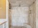 A spacious walk-in shower with neutral tiles, a built-in seat, and multiple shower heads at 2904 Pointer Pl, Seffner, FL 33584