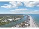 Expansive aerial view showcases the scenic coastline, lush waterways, and residential area, with the ocean extending far at 321 Bahia Vista Dr, Indian Rocks Beach, FL 33785