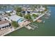 Aerial view showcases waterfront property with dock, lush landscaping, pool, and solar panels in a desirable neighborhood at 321 Bahia Vista Dr, Indian Rocks Beach, FL 33785