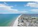 Panoramic aerial view featuring the coastline with a beach and city skyline in the background, under a bright, cloudy sky at 321 Bahia Vista Dr, Indian Rocks Beach, FL 33785