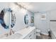 Elegant bathroom featuring dual sinks, decorative mirrors, and a separate toilet area for added privacy at 321 Bahia Vista Dr, Indian Rocks Beach, FL 33785