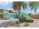 Beautiful turquoise home with well-maintained landscaping and a spacious driveway at 321 Bahia Vista Dr, Indian Rocks Beach, FL 33785
