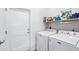 Practical laundry room with washer, dryer, and storage shelves for efficient organization at 321 Bahia Vista Dr, Indian Rocks Beach, FL 33785