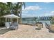 Relaxing waterfront patio featuring an umbrella-covered dining area and views of the water at 321 Bahia Vista Dr, Indian Rocks Beach, FL 33785