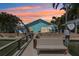 Back exterior features a wooden bench and dock overlooking the canal and patio with seating and an outdoor grill at 321 Bahia Vista Dr, Indian Rocks Beach, FL 33785