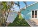 Landscaped side yard featuring artificial turf, a white fence, and access to the home at 321 Bahia Vista Dr, Indian Rocks Beach, FL 33785
