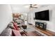 Bright and open living room featuring a large television, ceiling fan, and wood floors at 3307 E Comanche Ave, Tampa, FL 33610