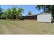 Expansive backyard featuring a storage shed, screened in porch, and well-maintained lawn at 39696 Meadowood Loop, Zephyrhills, FL 33542