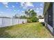 View of the fenced backyard featuring a green lawn and trees at 4007 W Gray St, Tampa, FL 33609