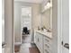 Hall bathroom featuring a white vanity, framed mirror and a peek into an office area at 4007 W Gray St, Tampa, FL 33609