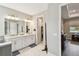 Bright bathroom showcasing double sinks with white cabinetry and a glimpse into the walk-in closet at 4007 W Gray St, Tampa, FL 33609
