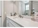 Bathroom vanity with framed mirror, white cabinets, bronze fixtures, and natural lighting at 4007 W Gray St, Tampa, FL 33609