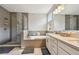 A modern bathroom featuring a soaking tub, dual sink vanity, and a glass-enclosed shower with a rainfall shower head at 4007 W Gray St, Tampa, FL 33609