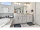A well-lit bathroom with a bathtub, double sink vanity with white cabinets, and modern fixtures for daily routines at 4007 W Gray St, Tampa, FL 33609