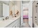 Bathroom with shower/tub, vanity with framed mirror, and open doorway into bedroom at 4007 W Gray St, Tampa, FL 33609