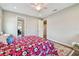 A well-lit bedroom with hardwood floors, colorful bedding, and access to a bathroom and walk-in closet at 4007 W Gray St, Tampa, FL 33609